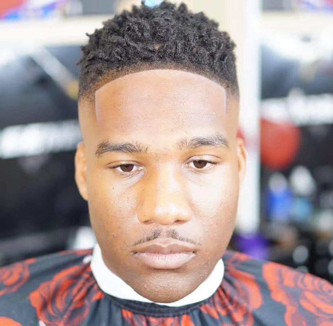 Front view of a high-top curl with a sharp squared line-up and a clean temple fade.