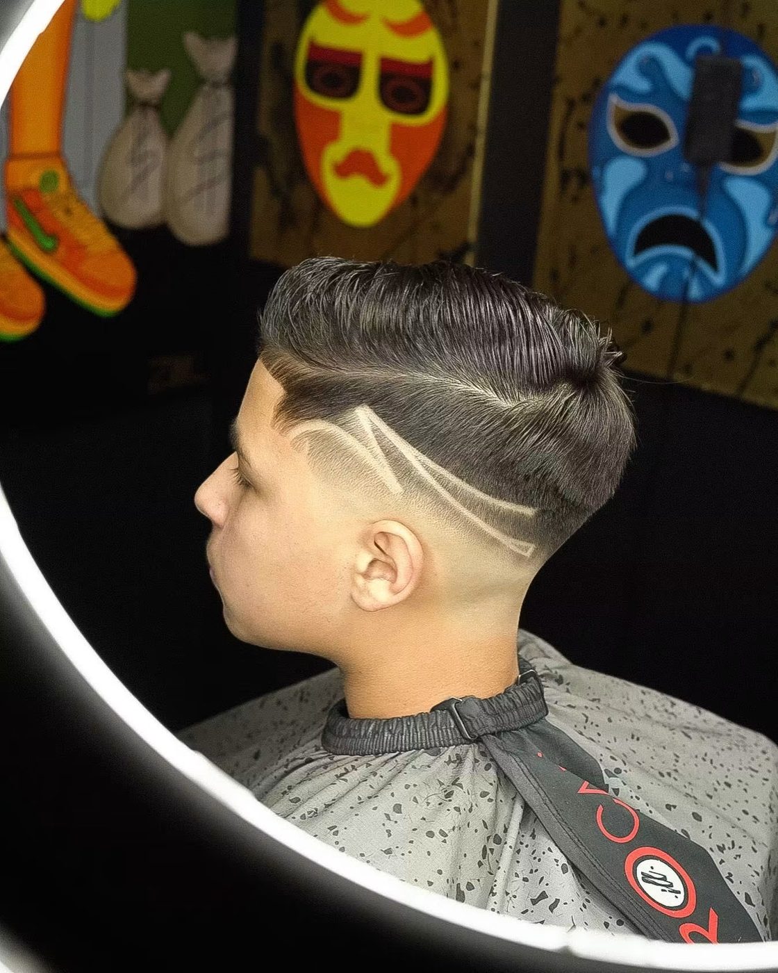 Textured comb-over with a razor design cut into the fade.