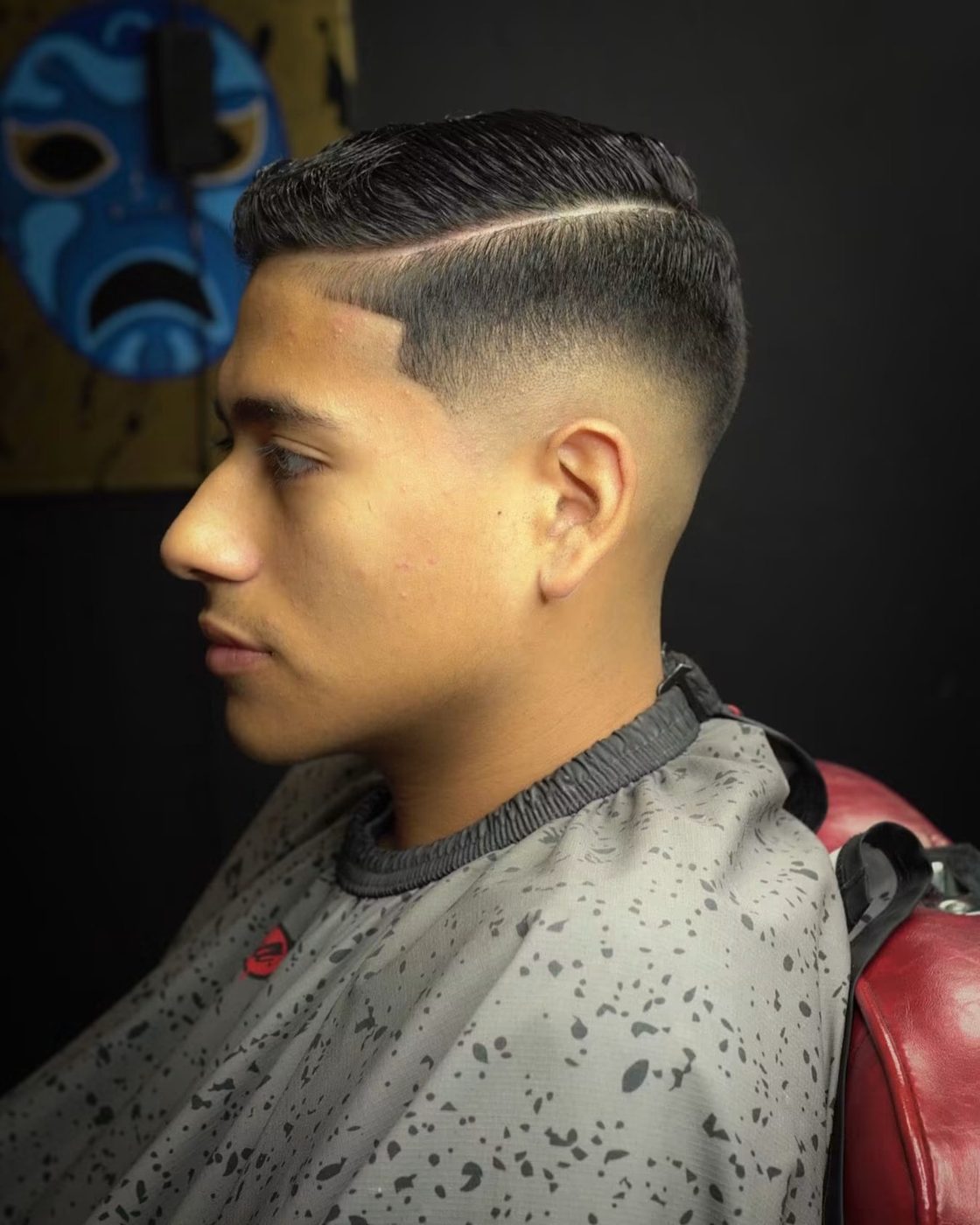 Side part fade with a razor-defined part and a tight skin taper.