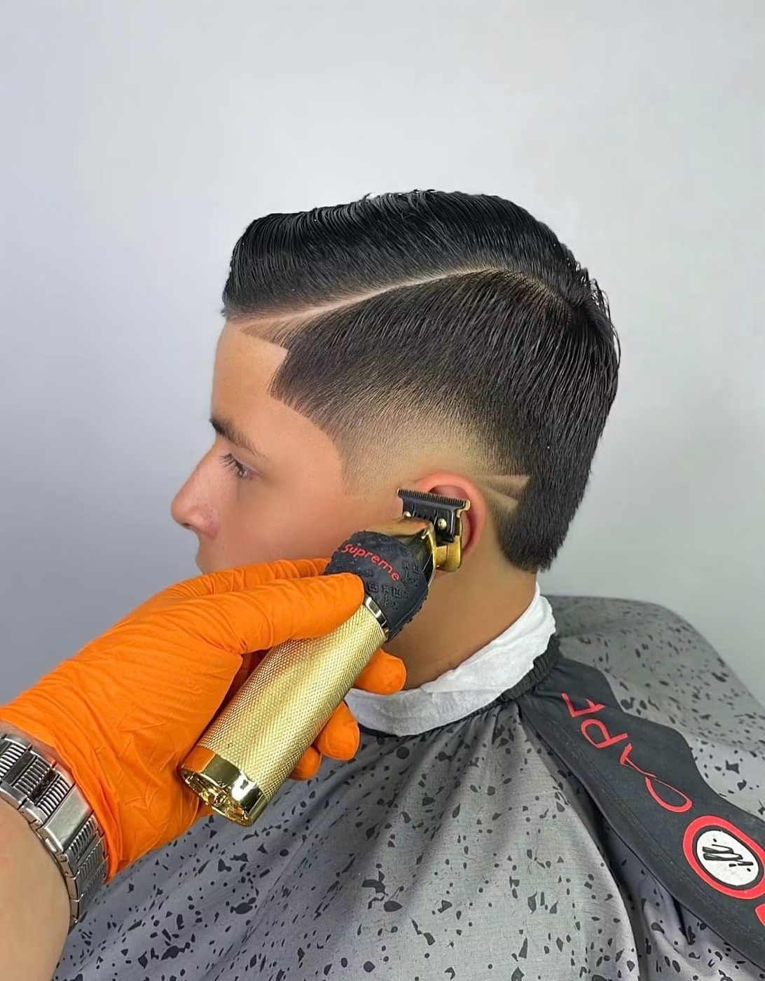 Trimmers detailing the neckline on a finished side part fade.