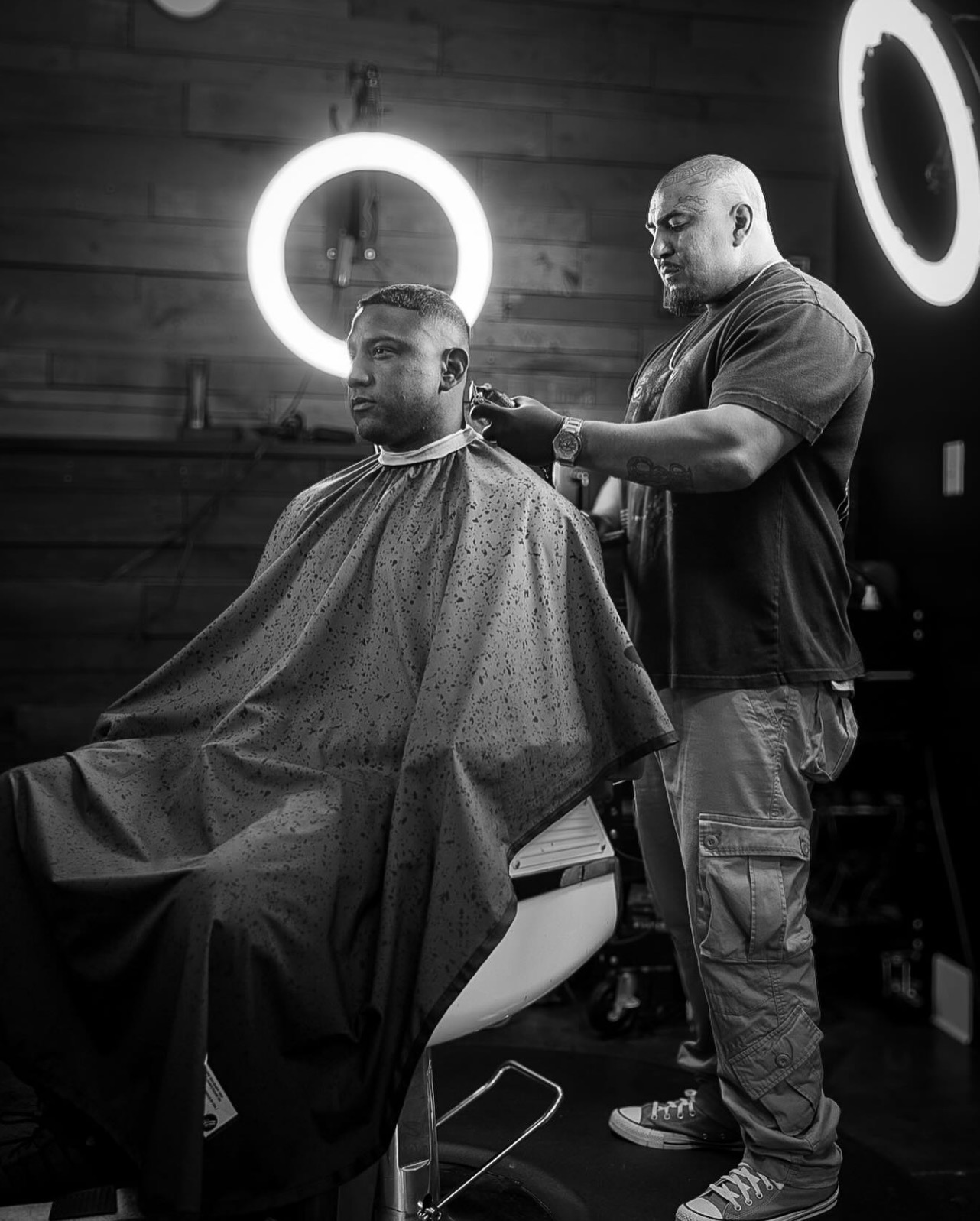 Lucky lining up a client's neckline under ring lights in his shop.